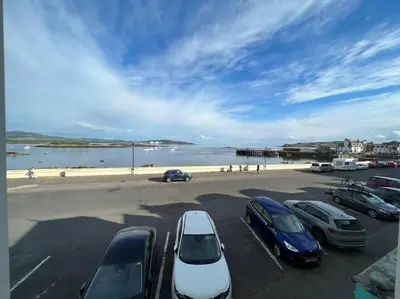 a parking lot with cars parked next to the beach at Fantastic 3 bedroom holiday home in Millport