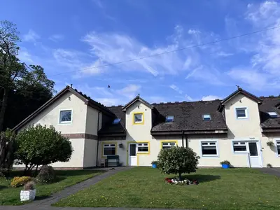a white house with a black roof at Cunninghame 2 in Beith