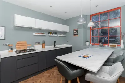 a kitchen with a table with chairs and a counter top at Beautiful & Bright 2BD Flat - Haymarket in Edinburgh