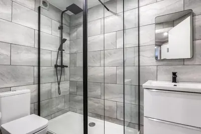 a bathroom with a shower and a toilet and a sink at ** Modern Merchant City 1 BED Apartment with Free Parking ** in Glasgow