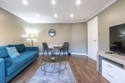 a living room with a blue couch and a table at ** Modern Merchant City 1 BED Apartment with Free Parking ** in Glasgow