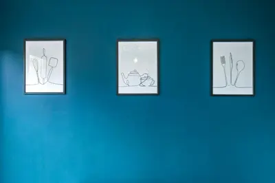 four framed drawings on a blue wall at I'm Your Host - Bridgeton House in Glasgow