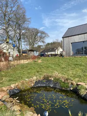 a pond of water with a building in the background at Granny’s Hut in Thornhill