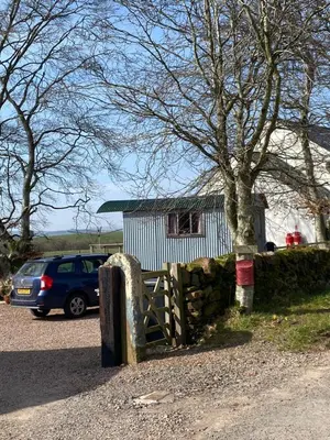 a car parked next to a fence and a house at Granny’s Hut in Thornhill