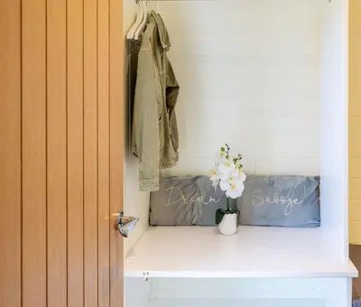 a closet with a shelf with a vase of flowers at East Kip - Dog Friendly in Penicuik