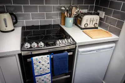 a kitchen with a stove and a counter top at Modern bright studio apartment in south Glasgow in Glasgow