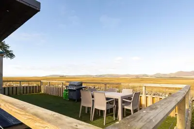 a patio with a table and chairs and a grill at South Black Hill in Penicuik