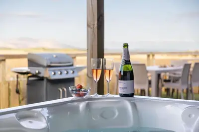 a bottle of champagne and two glasses on a tub at South Black Hill in Penicuik