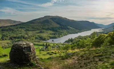 a stone hut on a hill overlooking a river at Sleeps 10. The Old pink library by loch and river in Lochearnhead