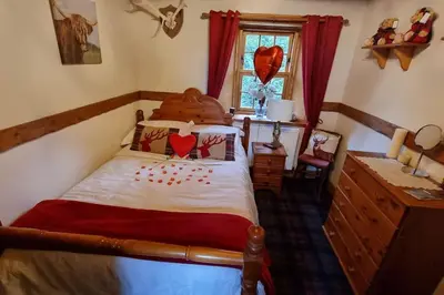 a bedroom with a bed and a window at Baidland Escapes 2 bedroom cottage With hot tub in Dalry