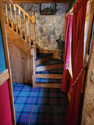 a hallway with stairs in a stone building at Baidland Escapes 2 bedroom cottage With hot tub in Dalry