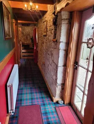 a hallway in an old building with a tile floor at Baidland Escapes 2 bedroom cottage With hot tub in Dalry