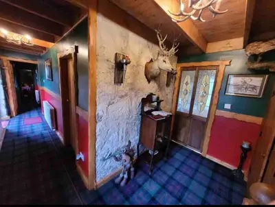 a room with a wall with a antler on the wall at Baidland Escapes 2 bedroom cottage With hot tub in Dalry