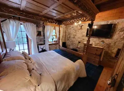 a bedroom with a large bed and a tv at Baidland Escapes 2 bedroom cottage With hot tub in Dalry
