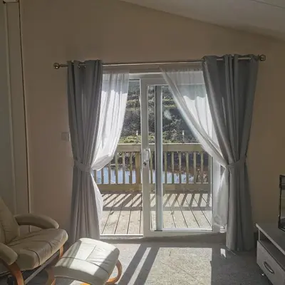 a room with a sliding glass door with a balcony at Homeston Lodge in Drumlemble
