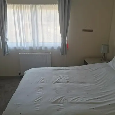 a large white bed in a bedroom with a window at Homeston Lodge in Drumlemble