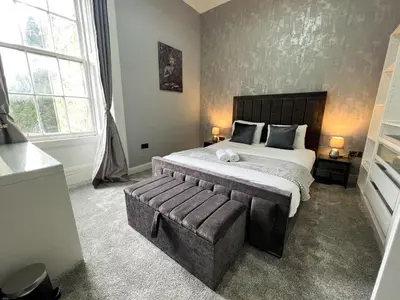a bedroom with a large bed and a large window at Premium 2BR Flat in the City Centre in Glasgow