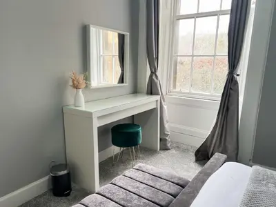 a bedroom with a vanity with a mirror and a chair at Premium 2BR Flat in the City Centre in Glasgow