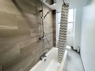 a bathroom with a shower and a bath tub at Premium 2BR Flat in the City Centre in Glasgow