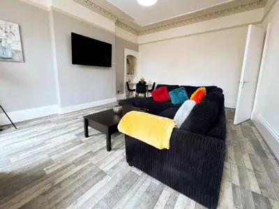 a living room with a black couch with colorful pillows at Premium 2BR Flat in the City Centre in Glasgow