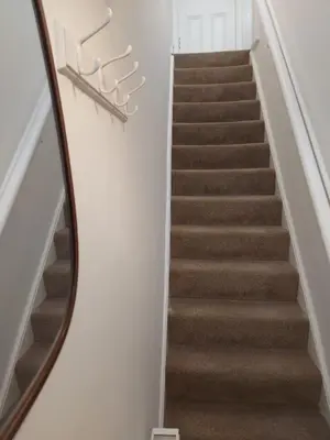 a stairway with a mirror on the wall at Black Cat Cottage in Moffat