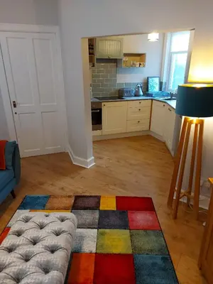 a living room with a colorful rug on the floor at Black Cat Cottage in Moffat