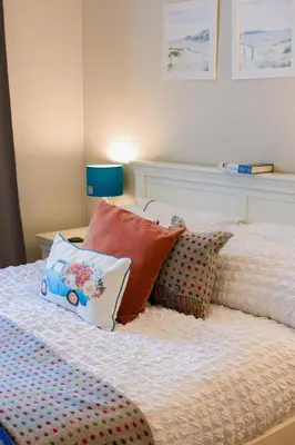 a bed with pillows on it with at Small Cosy Studio Flat Near the Sea, Central Oban in Oban