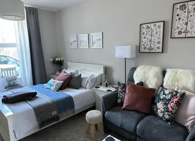 a bedroom with a bed and a couch at Small Cosy Studio Flat Near the Sea, Central Oban in Oban