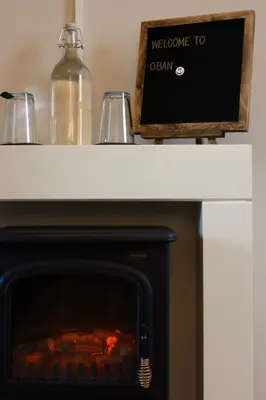 a fireplace with a welcome to oven sign on top of it at Small Cosy Studio Flat Near the Sea, Central Oban in Oban