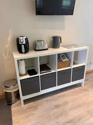 a white cabinet with shelves and a tv on top at Wrens nest in Newton Stewart