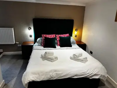 a bedroom with a large bed with towels on it at Netherby Guest House Edinburgh in Edinburgh