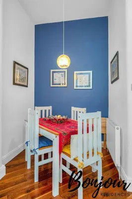 a dining room with a table and a blue wall at Anvers Suite in Edinburgh