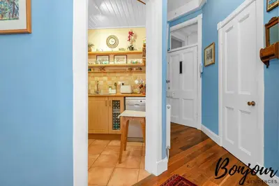 a kitchen with blue walls and a table in a hallway at Anvers Suite in Edinburgh