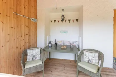 two chairs sitting around a table in a room at The Mews - a cottage with a spectacular lake view in Port of Menteith