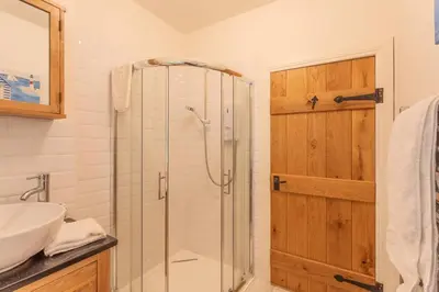 a bathroom with a shower and a sink at The Mews - a cottage with a spectacular lake view in Port of Menteith