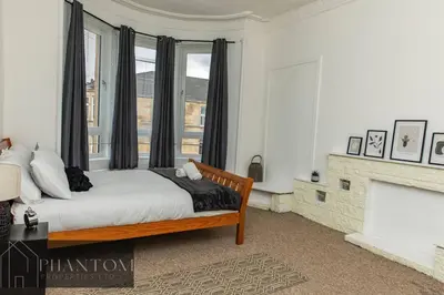 a bedroom with a large bed and a fireplace at Complex Suite in Glasgow