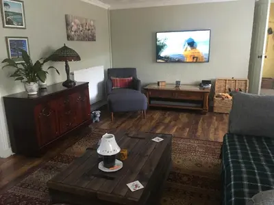 a living room with a couch and a tv at Minton cottage in Leadhills