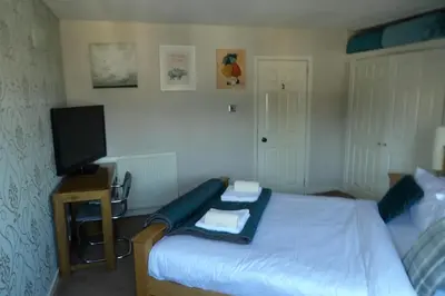 a bedroom with a bed with a tv and a bedskirtspectspectspectspects at Aigas Cottage in Glasgow