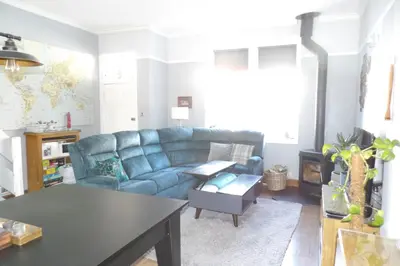 a living room with a blue couch and a table at Aigas Cottage in Glasgow