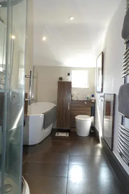 a bathroom with a tub and a toilet and a sink at Aigas Cottage in Glasgow