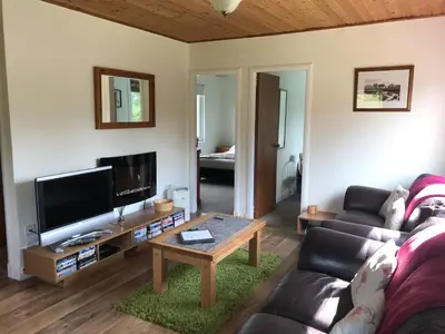a living room with a couch and a table at Glengarry Lodge in Tyndrum