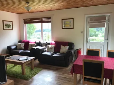 a living room with a couch and a table at Glengarry Lodge in Tyndrum