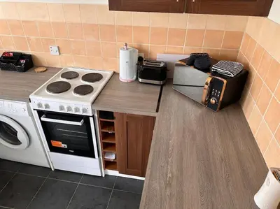 a kitchen counter with a stove and a microwave at Semi-detached chalet at Maryville Caravan Site - Uddingston, Glasgow in Uddingston