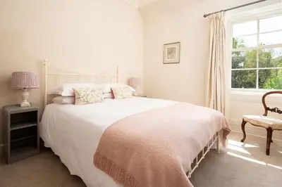 a white bedroom with a bed and a window at Mossfennan House & Annexe in Drummelzier