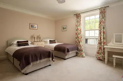 a bedroom with two beds and a window at Mossfennan House & Annexe in Drummelzier