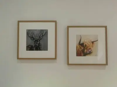 two pictures of animals are hanging on a wall at Historic cottage next to loch lomond Luss in Alexandria