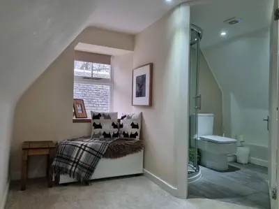 a bathroom with a shower and a bench and a sink at Historic cottage next to loch lomond Luss in Alexandria