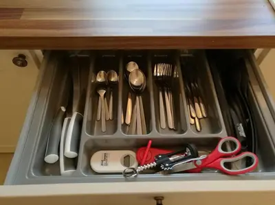 a drawer filled with utensils in a cabinet at Historic cottage next to loch lomond Luss in Alexandria
