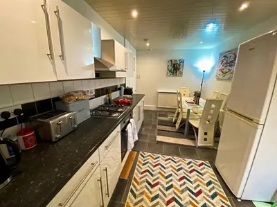 a kitchen with white cabinets and a counter top at Paisley Pad Glasgow Gateway second floor flat in Paisley