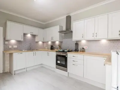 a white kitchen with white cabinets and appliances at Mars Hill Lower in Dunoon